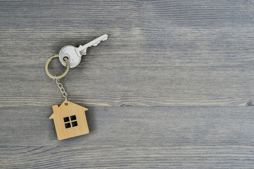 Fototapeta na wymiar Metal key lock home in bamboo keychain for wooden rustic gray background. Copy space