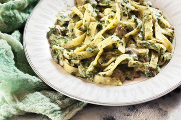 Tagliatelle pasta with spinach and mushrooms on a plate
