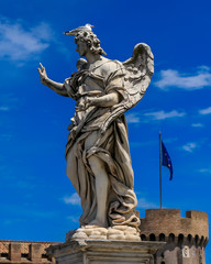 Bird is sitting on the statue of an angel, on the background Castle Sant'Angelo, Rome, Italy