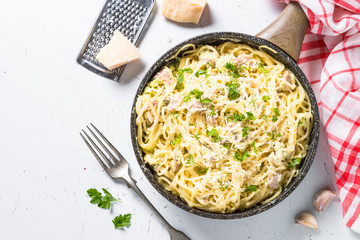 Pasta carbonara with bacon and cream sauce on white. 