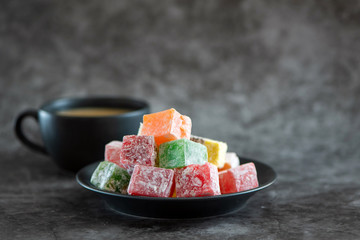 Traditional turkish delight and cup of coffee on grey background