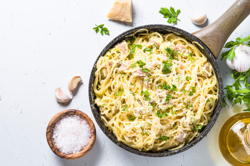 Pasta carbonara with bacon and cream sauce on white. 