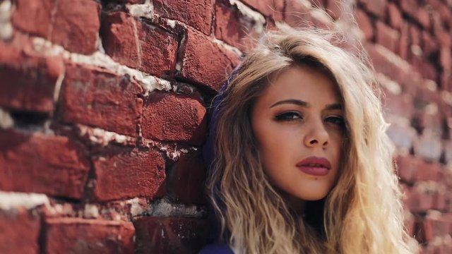 Attractive young woman in hoodie sweatshirt looking into the camera