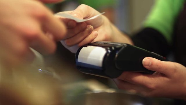 The buyer pays by applying the card to the payment terminal and the seller issues a check. Close-up