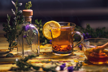 Black tea with lemon in a transparent mug, violet flowers, beaut