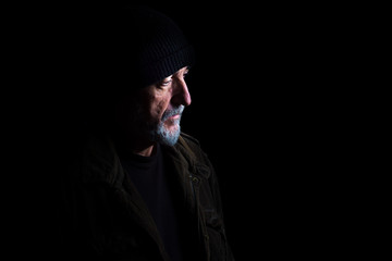 Portrait of adult man with hat, isolated on black background