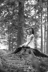 Authentic young woman in a white dress with trees in the background
