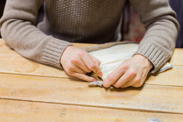 Professional male skinner, furrier working with mink fur skin at atelier, workshop. Fashion and leatherwork concept