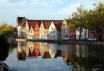 Fototapeta na wymiar Quay of the canal in Bruges, Belgium. Reflection of houses in water 