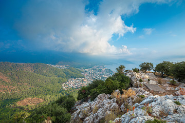 Fototapeta na wymiar Aerial view to the city located on the sea coast from the height of the mountain path. Morning landscape.