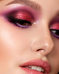 Closeup portrait of young beautiful woman with bright pink smokey eyes and lips. Fashion makeup. Studio shot. Modern summer make up. Extreme closeup, partial face view