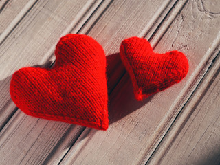 knitted red hearts symbolizing love on a wooden white table