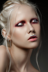 Close up beauty portrait of young woman with red and silver make up. Perfect skin and fashion make...