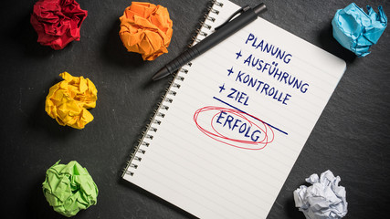 Motivierende Begriffe auf einem Notizbuch am Arbeitsplatz 