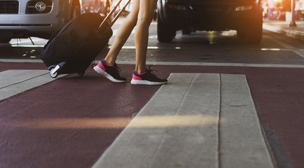 Closeup legs of woman walking step on steert at airport holding suitcase for travel near city, girl happy lifestyle relaxation.