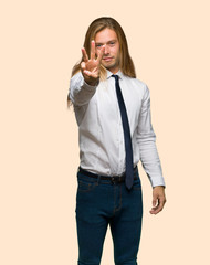 Blond businessman with long hair happy and counting three with fingers on isolated background