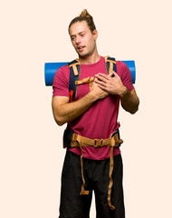 Hiker man with mountain backpacker having a pain in the heart on isolated background
