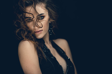 Naklejka premium Girl in a leather dress posing for a photographer in the studio. Stylish photo zone in creative colors.