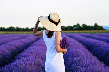 Young woman in a white dress on a lavender filed