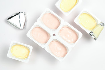 Plastic cup with tasty yogurt isolated on white. Top view. Space for text or design.