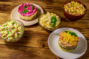 Set of festive mayonnaise salads on wooden table
