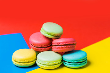 Fototapeta na wymiar Close up of colorful red, yellow and blue background with cake macarons