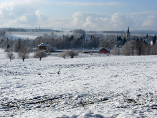 Fototapeta premium Aerial view of small village covered with fresh snow, winter time, sunny day