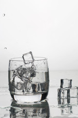 water with ice in a glass with splashes