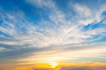 Sky blue and orange light of the sun through the clouds in the sky