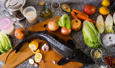 Top view of sturgeon with vegetables on stone table