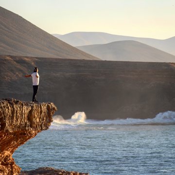Man on top of ocean cliffs