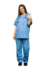 Full body of Young nurse points finger at you with a confident expression