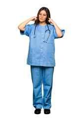 Full body of Young nurse covering both ears with hands