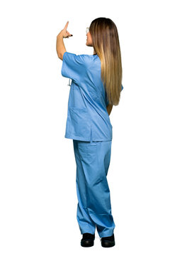 Full Body Of Young Nurse Pointing Back With The Index Finger