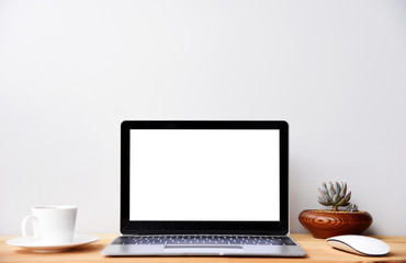 blank screen Modern laptop computer with coffee cup,mouse and Succulent on wood table in office view backgrounds
