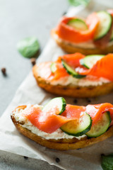 Salmon, cucumber and cream cheese bruschetta. Italian tapas, antipasti with vegetables, herbs and oil on grilled ciabatta and baguette bread. Sandwich.