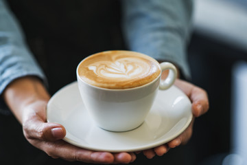 Latte art coffee in hands