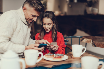 Man spending his time with daughter using cellular