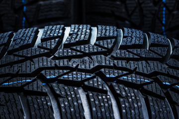 Set of new winter tires on black background with contrasty lighting. Close up product photograph of...