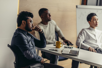 Group of strategy managers reading last business reports from exchanges on laptop and pesonal...