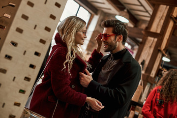 Happy young couple wearing sunglasses at small street market and laughting