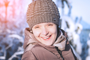 Woman smiling in the woods and looking into the frame