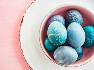 Easter eggs painted in bright colors on a pink background. Top view, close-up, isolated. Happy Easter. Preparation for the holiday