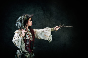 Sexy pirate in profile holding a musket in his hands
