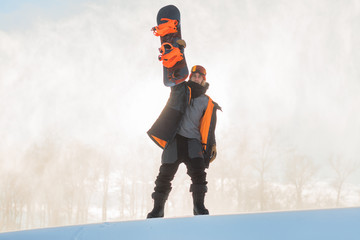 happy snowboarder holding a board in the hands and looking at the camera. achievement. happiness,...