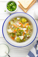 Vegetable soup with cauliflower, Brussels sprouts, white cabbage, carrots and green peas. Delicious healthy lunch, spring food