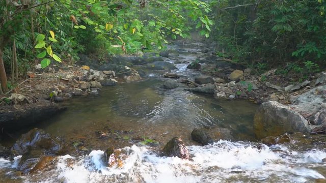 clear water stream or waterfall with tree and rock or stone in green jungle or forest for summer holiday relax and travel vacation trip at Ban Krang Camp in Kaeng Krachan National Park Thailand slow