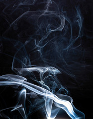 Smoke catching the light against a black background