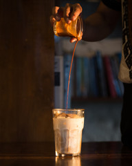 Barista pouring coffee into glass