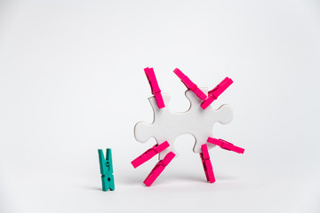 element of a clean puzzle with attached paper clips in the same color and one in a different color